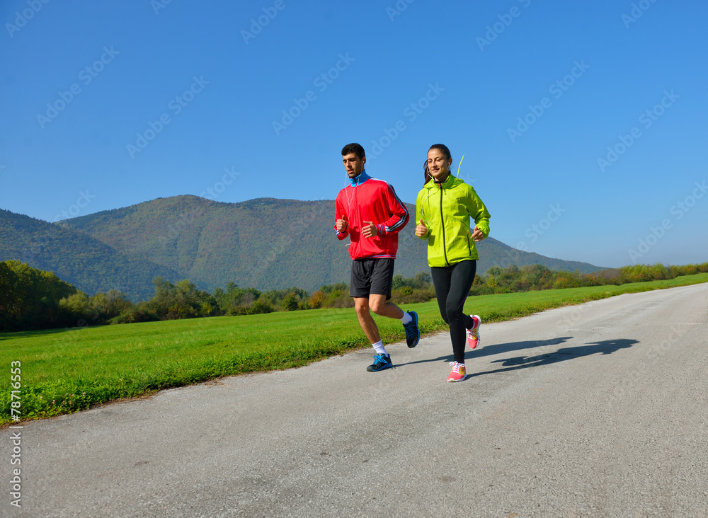Obraz premium Young couple jogging in park at morning. Health and fitness.