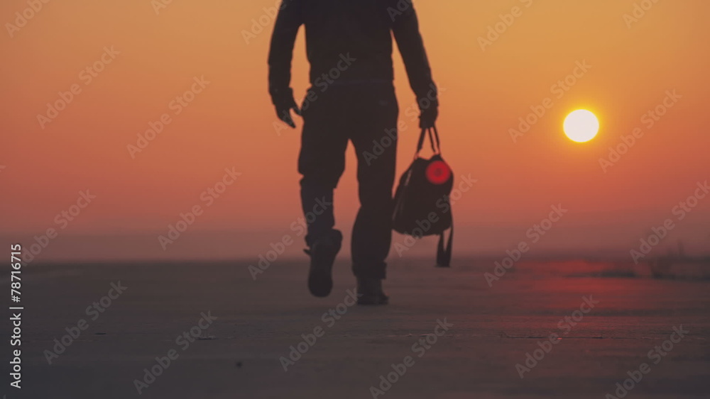 A man gets under way on a journey with a bag on the east