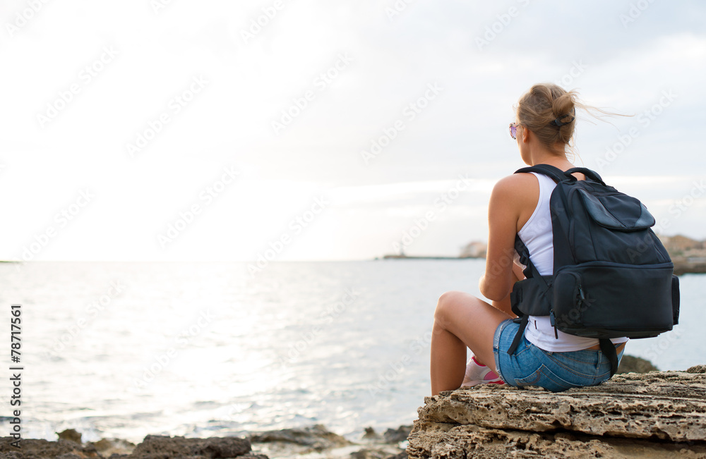 Woman with backpack relaxing near the sea.