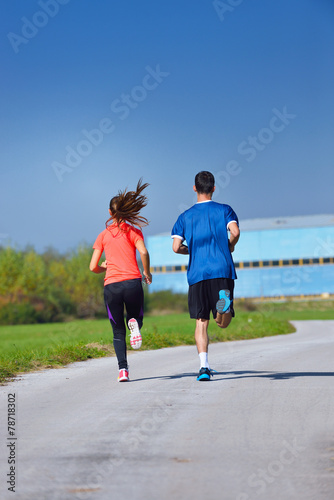 Young couple jogging in park at morning. Health and fitness. © blicsejo