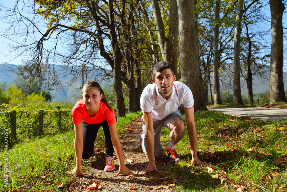 Fototapeta premium Young couple jogging in park at morning. Health and fitness.