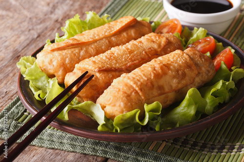 fried spring rolls on a plate and chopsticks closeup. horizontal
