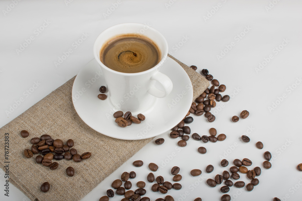 Obraz premium Coffee cup and beans on a white background.