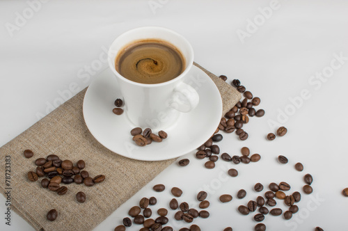 Coffee cup and beans on a white background. © kostyha