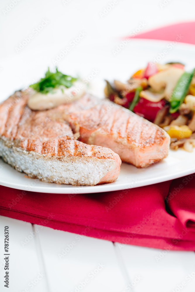 Grilled Salmon with Fresh vegetables on red background