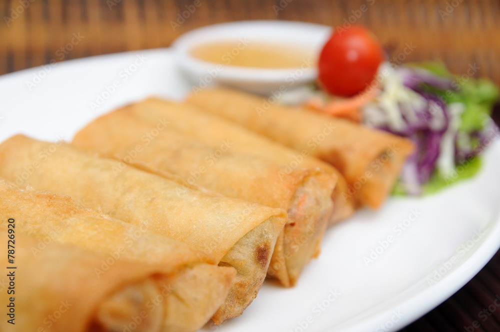 Fried spring rolls on white plate.