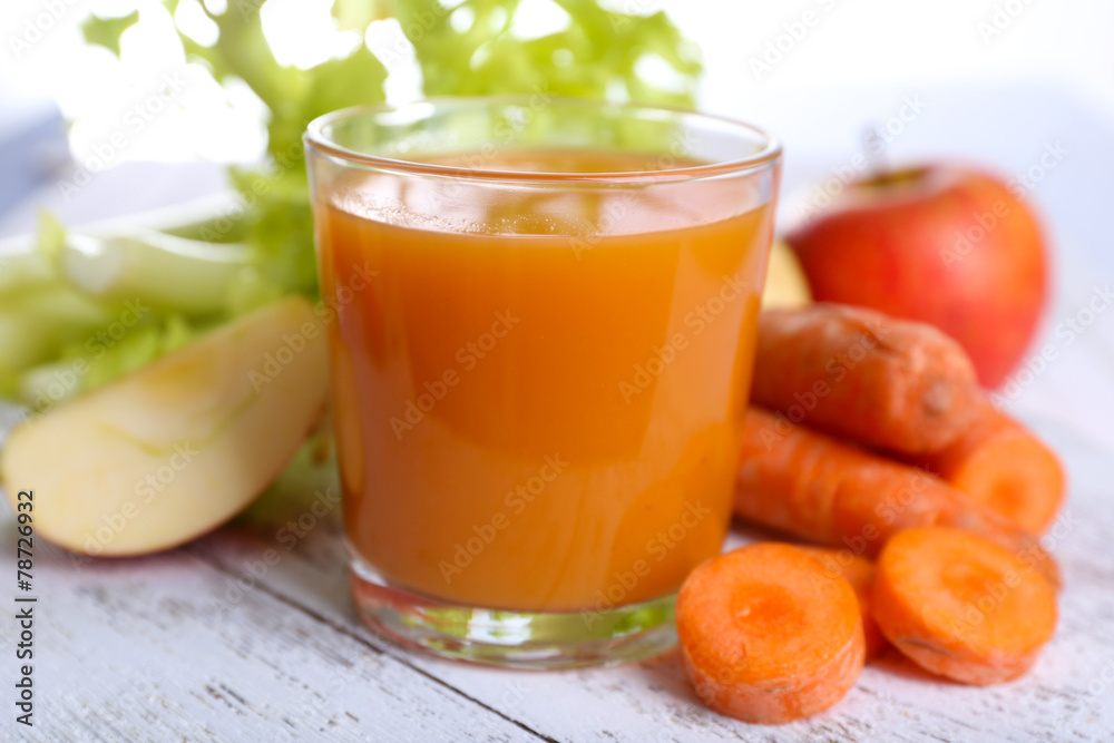 Glass of juice with apple and carrot on wooden table close up Glass of juice with apple and carrot on wooden table close up