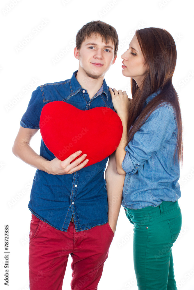 Eautiful young happy couple kissing behind a red heart