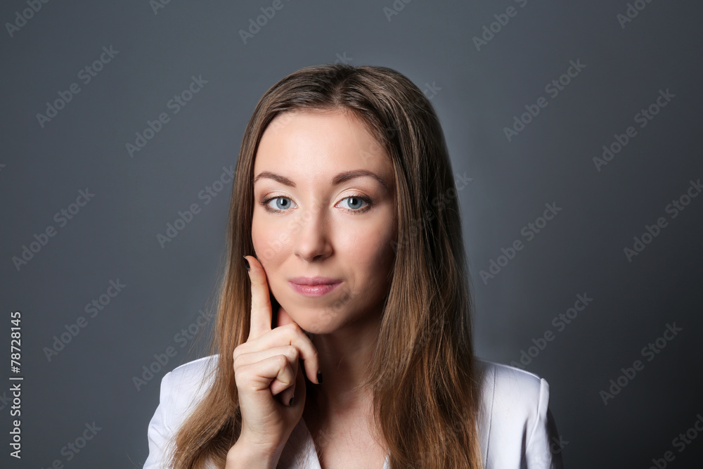 Portrait of young woman on grey background