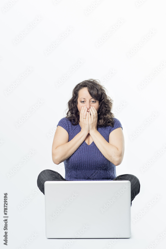Young woman with surprise expression in front of laptop Young woman with surprise expression in front of laptop