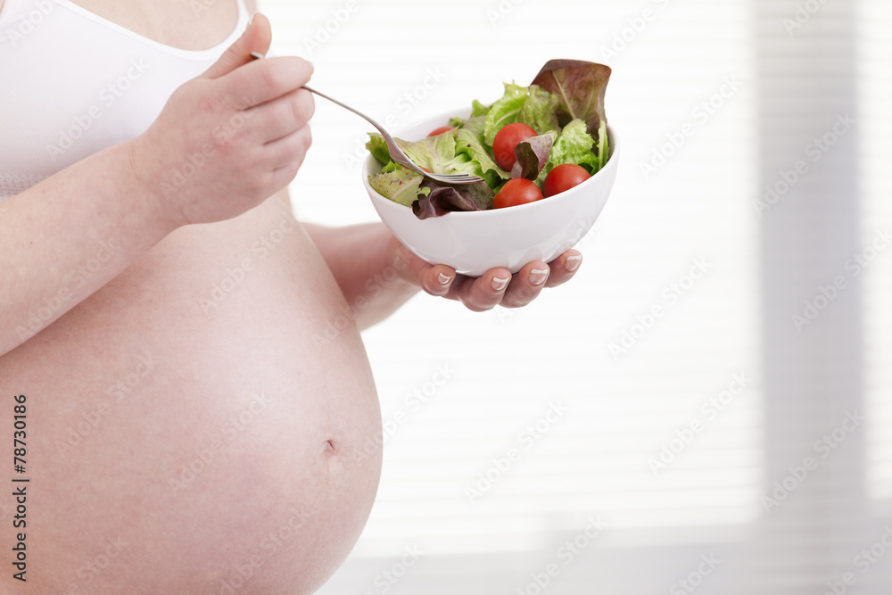 Pregnant woman holding a bowl of fresh salad Pregnant woman holding a bowl of fresh salad