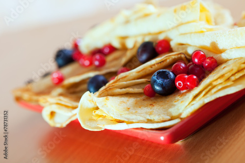  pancakes on plate with cranberries and blueberries photo