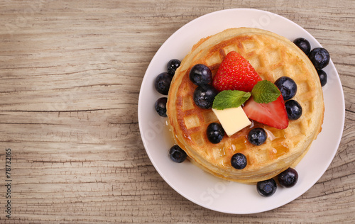 Waffles with Strawberry and Blueberry over wooden background