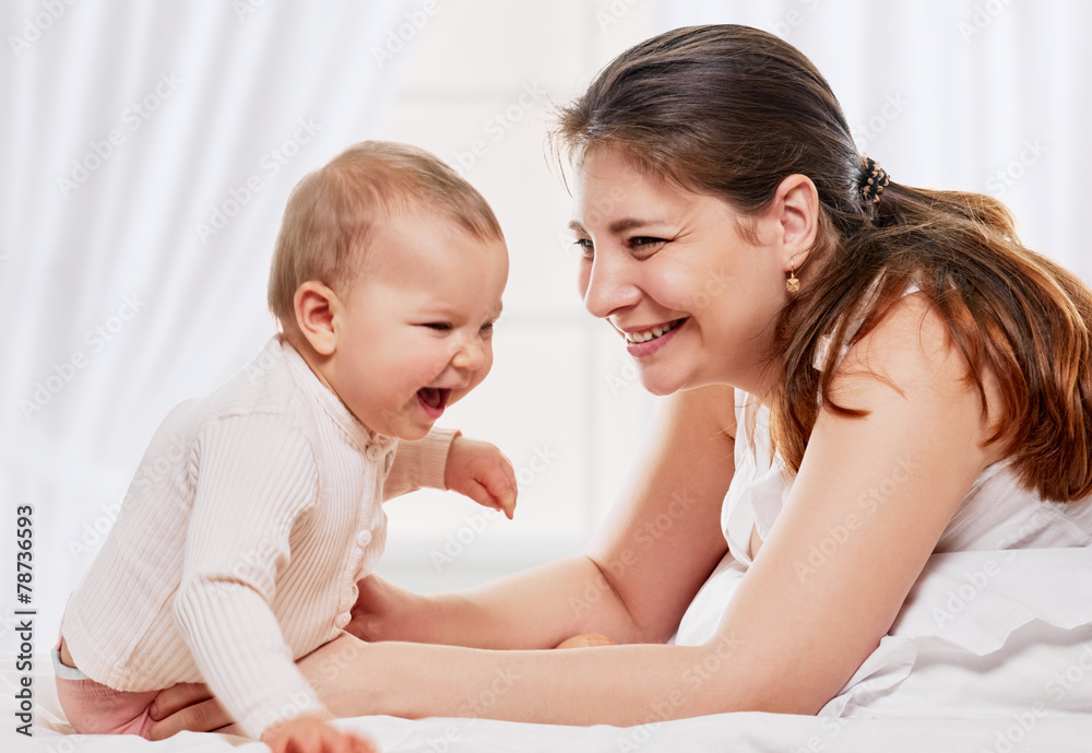 Woman and daughter playing in bed
