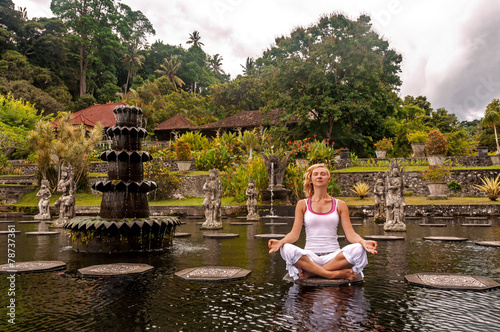 Women meditation near Water Palace Tirthagangga. Bali Indonesia photo