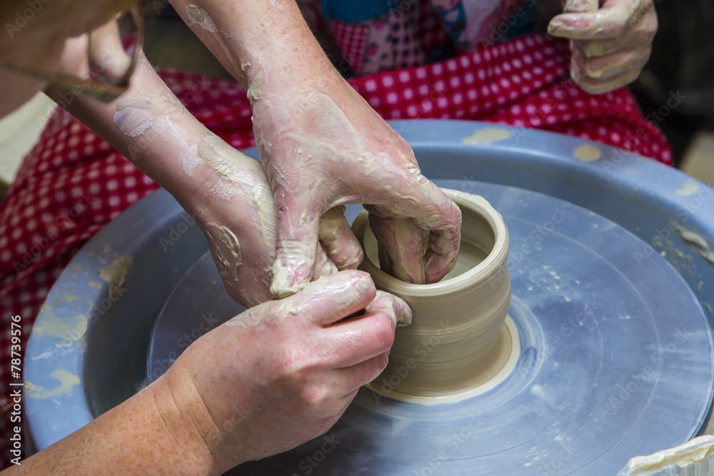 master potter holds a lesson for modeling on a potter's wheel master potter holds a lesson for modeling on a potter's wheel