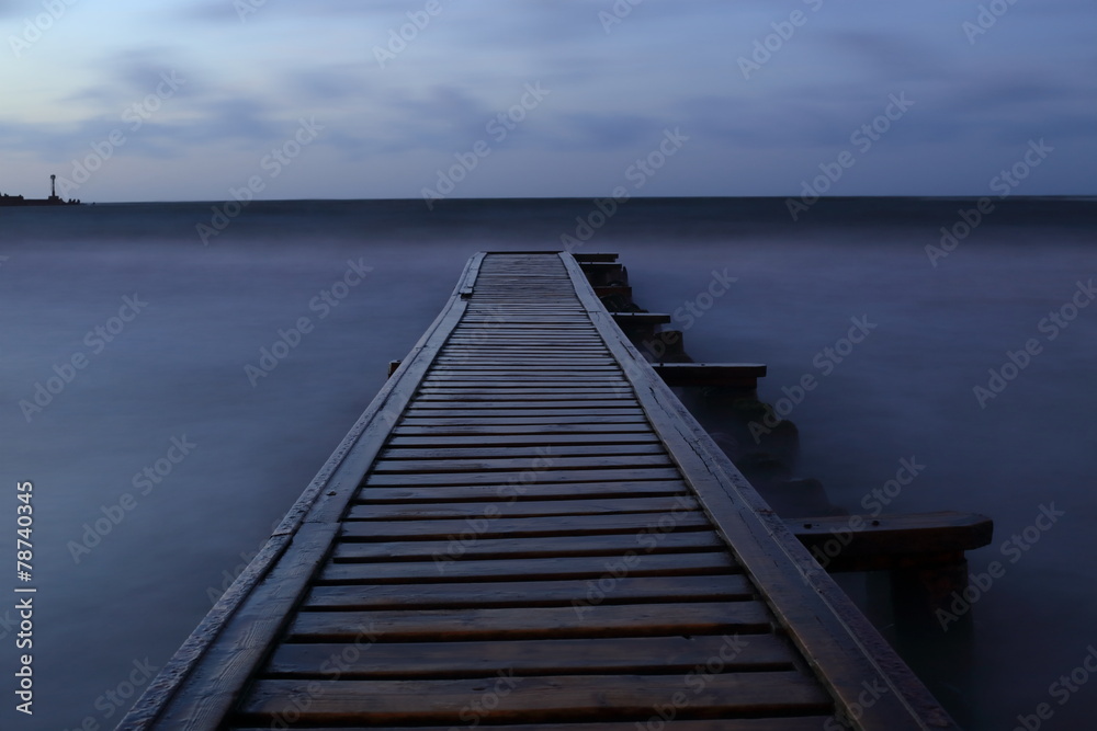 Pier into the sea at night
