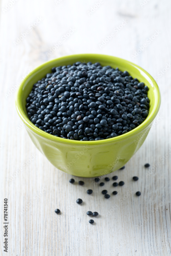 black lentils on table in bowl black lentils on table in bowl
