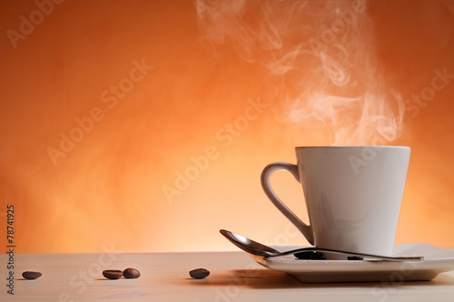 Cup of coffee with orange background front view