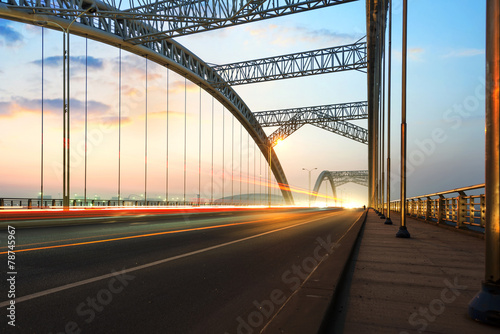 Fototapeta Naklejka Na Ścianę i Meble -  road through the bridge with blue sky background of a city