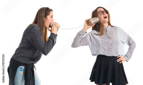 Quadro su tela Twin sisters talking through tin phone