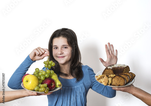 Girl choose to eat organic fruits - grapes, apples, pears