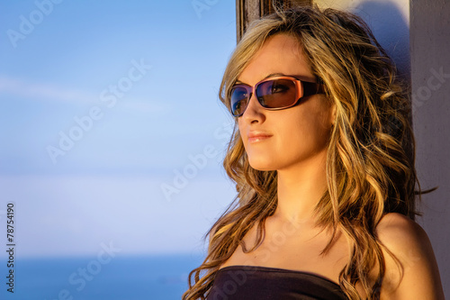 Curly blonde girl with black top and sunglasses
