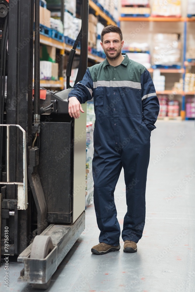 Manual worker leaning against the forklift