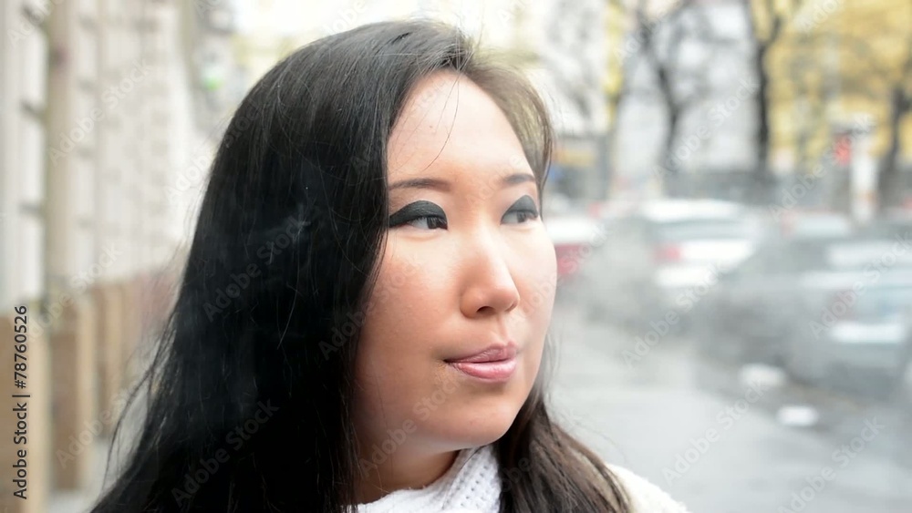 young attractive asian woman smokes - street - closeup young attractive asian woman smokes - street - closeup