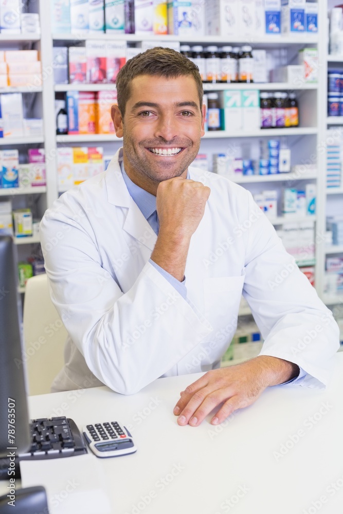 Happy pharmacist using the computer