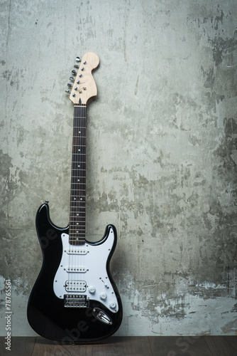 Electric guitar near the concrete wall © Room 76 Photography