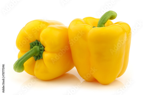 two yellow bell peppers (capsicum) on a white background