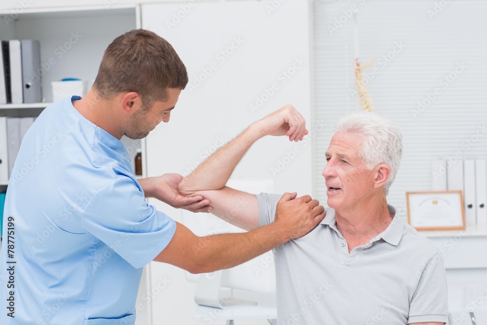 Fototapeta premium Physiotherapist giving massage to senior man