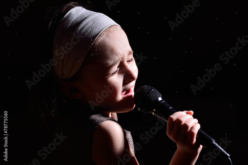 Little girl singing on the microphone