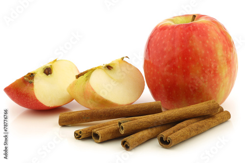 dried cinnamon sticks, fresh apples on a white background