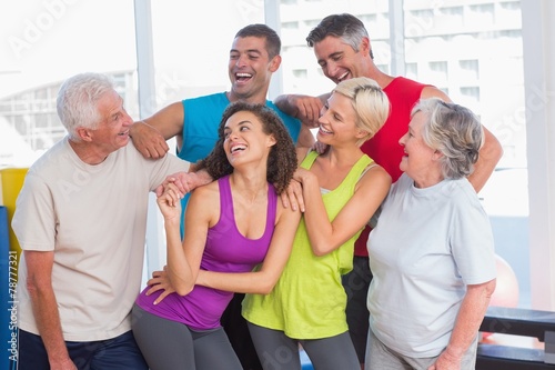 Playful friends looking at man at fitness studio
