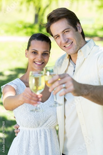 Happy couple toasting in the park