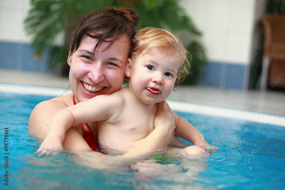 Mother play with her lovely child in swimming-pool