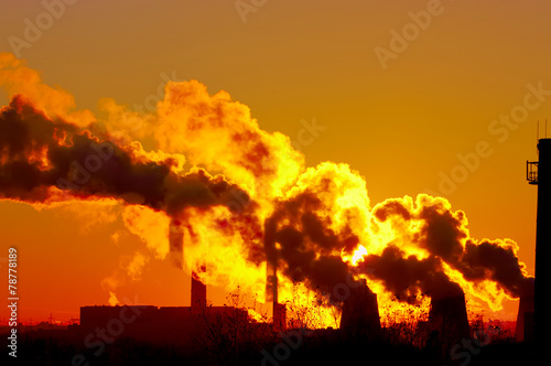 power plant smokestacks at sunset