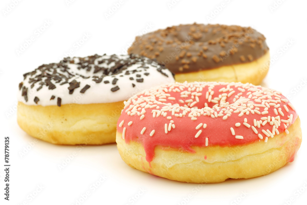 assorted colorful glazed donuts with sprinkles on a white backgr