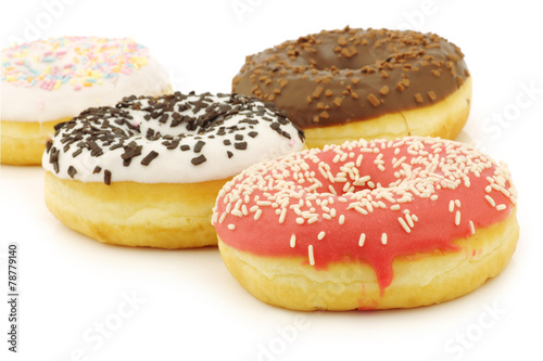 assorted colorful glazed donuts with sprinkles on a white backgr