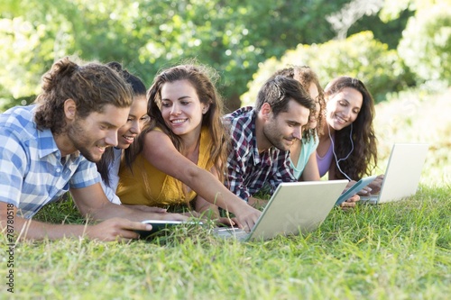 Smiling friends in the park using tablet pc and laptop © WavebreakMediaMicro