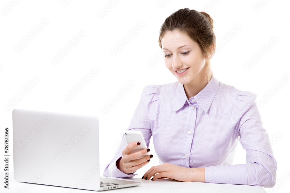 Young girl texting with smartphone in front of laptop Young girl texting with smartphone in front of laptop