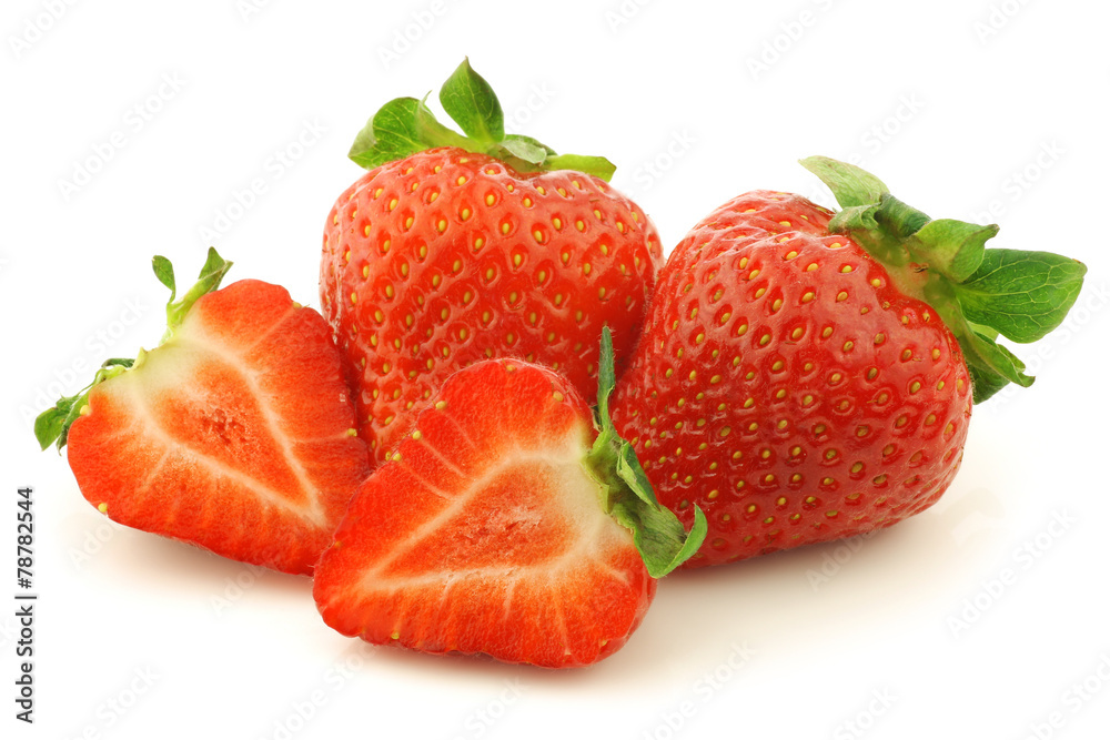 fresh strawberries and a cut one on a white background fresh strawberries and a cut one on a white background