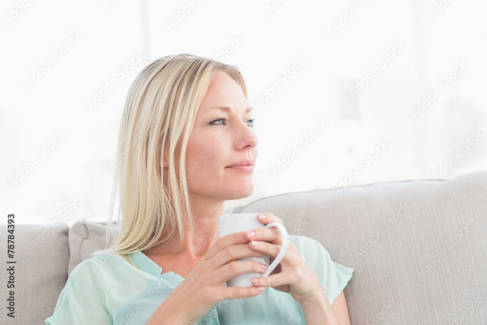 Woman holding coffee cup while looking away Woman holding coffee cup while looking away