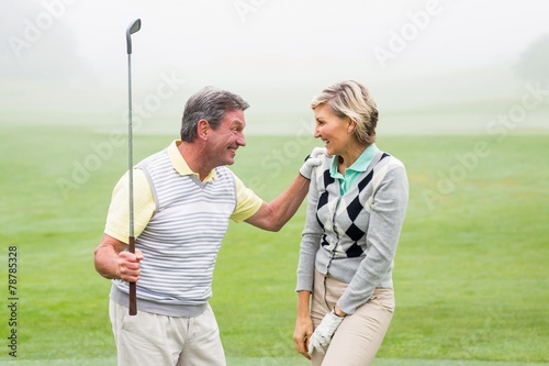 Excited golfing couple cheering