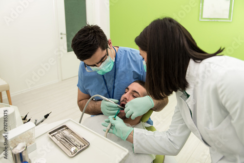 Dentist Curing A Male Patient