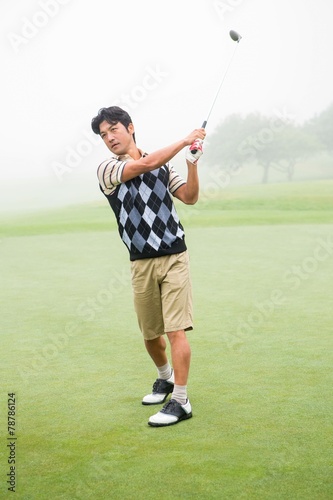 Golfer teeing off