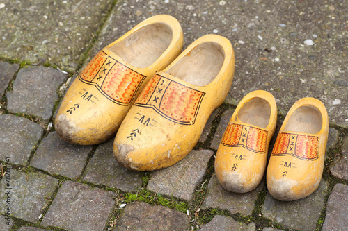 pair of traditional Dutch yellow wooden shoes on a stone footpat