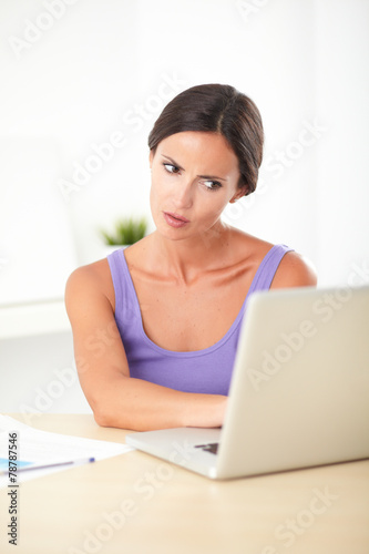 Young angry woman working on the computer